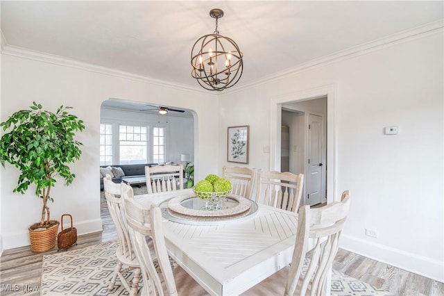 dining room with crown molding, ceiling fan with notable chandelier, and light wood-type flooring