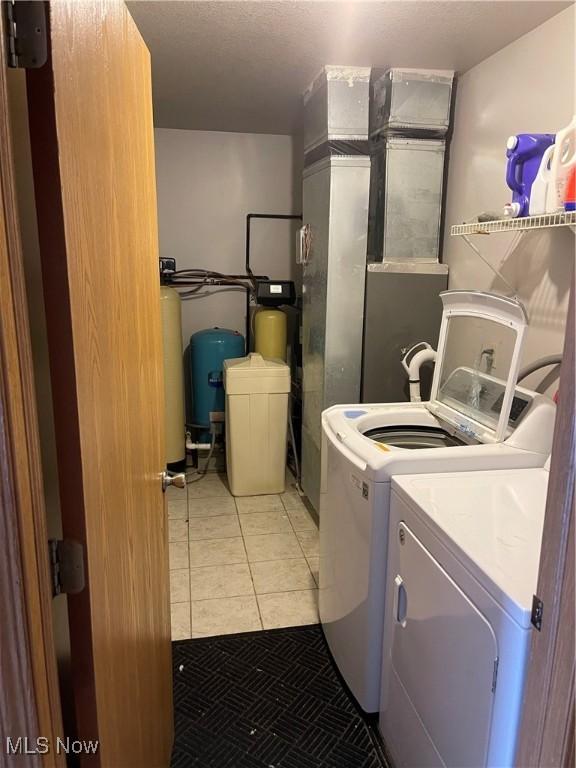 laundry room featuring light tile patterned floors and washing machine and clothes dryer