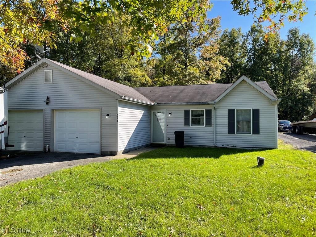 single story home with a garage and a front yard