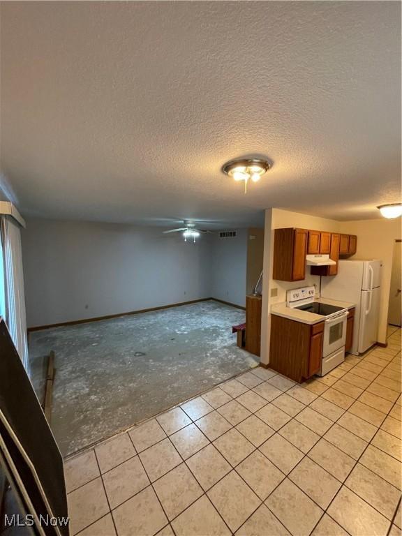 kitchen featuring white appliances, a textured ceiling, and ceiling fan