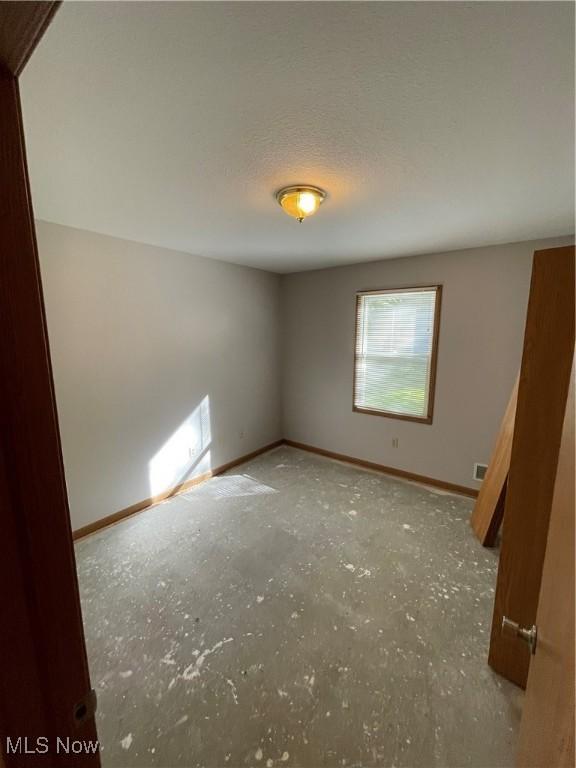 unfurnished room featuring a textured ceiling