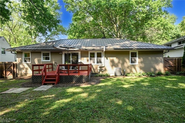 rear view of property featuring a wooden deck and a yard