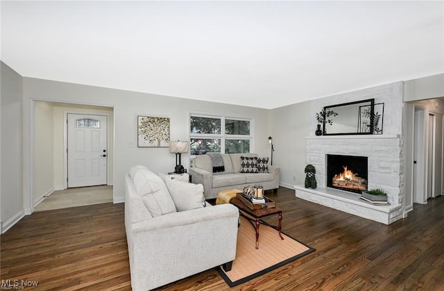 living room with dark wood-type flooring and a fireplace