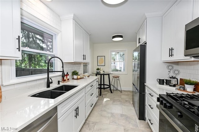 kitchen with light stone counters, sink, black appliances, and white cabinets