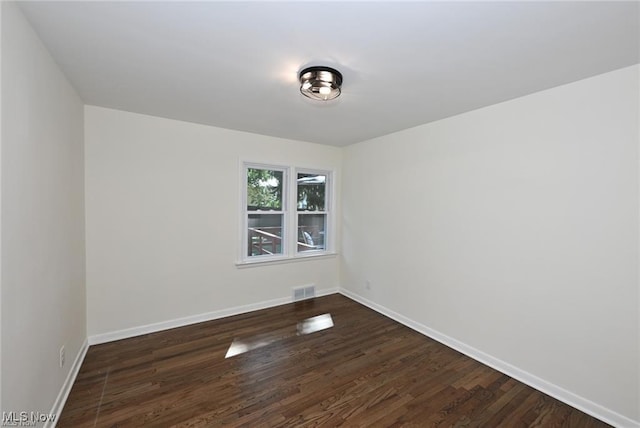 unfurnished room featuring dark wood-type flooring