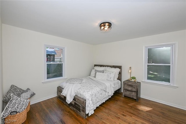 bedroom with multiple windows and dark hardwood / wood-style flooring