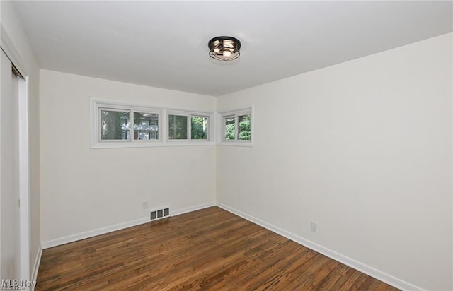 unfurnished room featuring dark hardwood / wood-style flooring