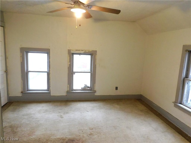 carpeted empty room featuring lofted ceiling