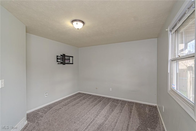 empty room with carpet and a textured ceiling