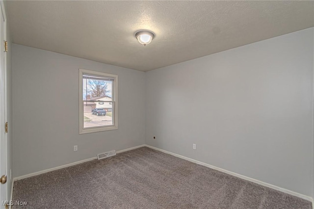 unfurnished room featuring a textured ceiling and carpet flooring