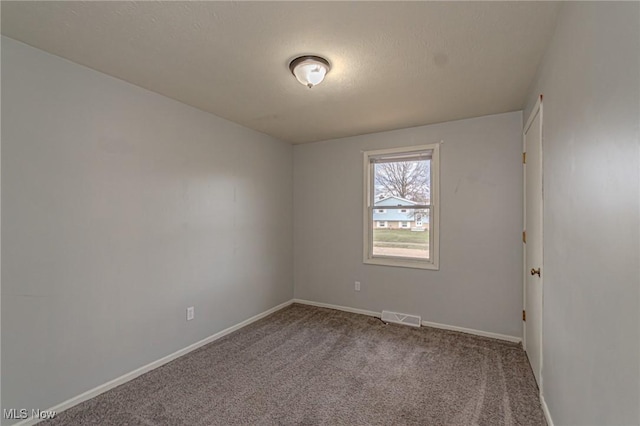 unfurnished room with carpet floors and a textured ceiling