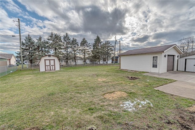 view of yard featuring a garage, a patio, and a storage shed