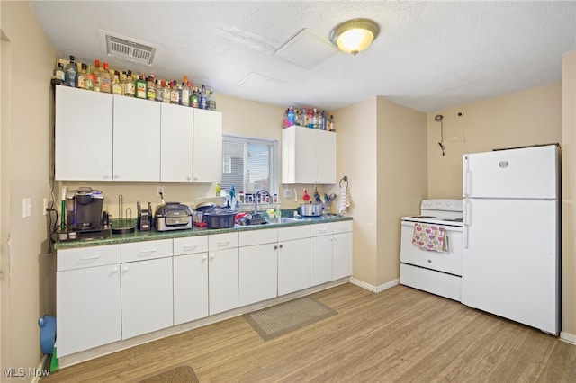 kitchen featuring sink, white cabinets, white appliances, and light hardwood / wood-style flooring