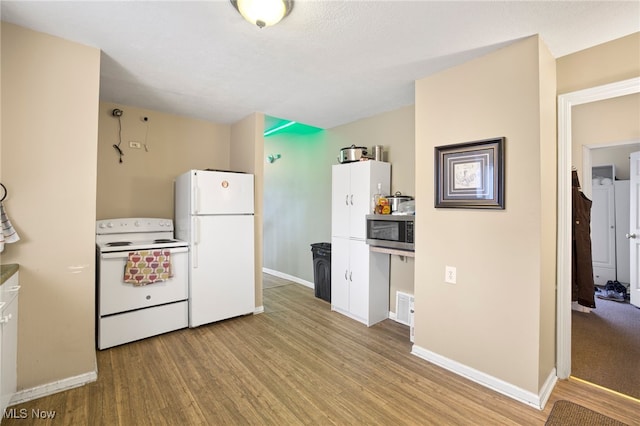 kitchen with white appliances and light wood-type flooring