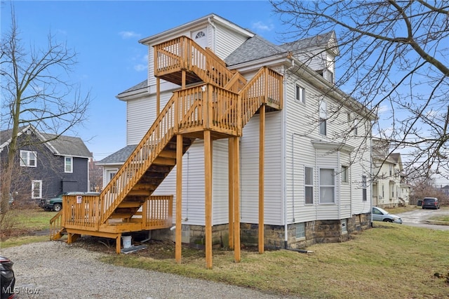 exterior space featuring a wooden deck and a front lawn