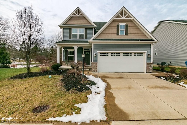 craftsman house featuring a porch, a garage, and a front lawn