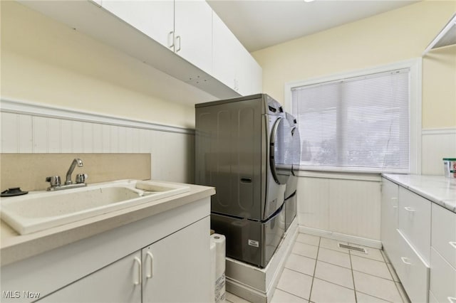 washroom featuring cabinets, separate washer and dryer, sink, and light tile patterned floors