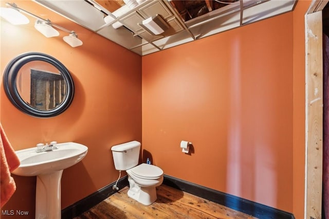 bathroom with hardwood / wood-style floors, sink, and toilet