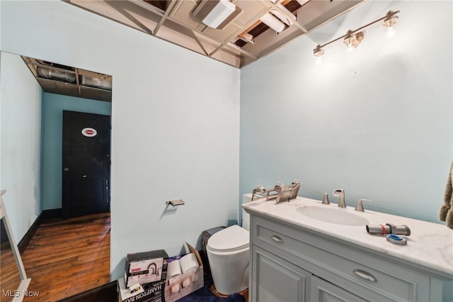 bathroom featuring vanity, hardwood / wood-style floors, and toilet