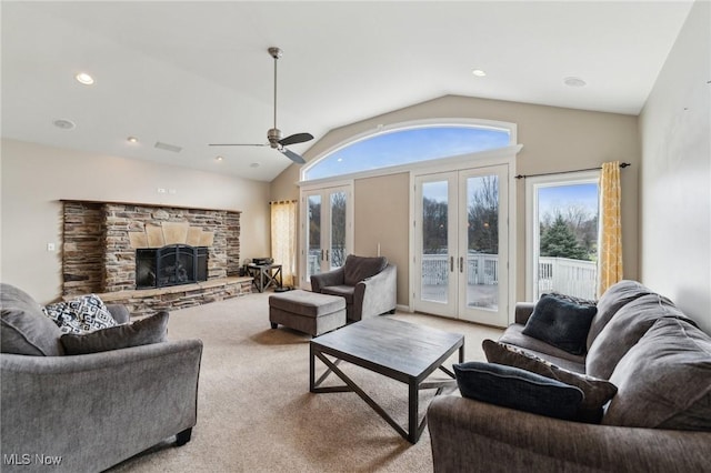 carpeted living room featuring lofted ceiling, a fireplace, french doors, and ceiling fan