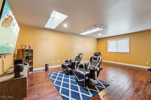 sitting room with wood-type flooring and a skylight