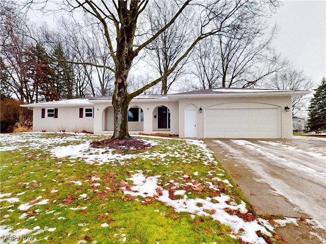 ranch-style home with a garage and a lawn