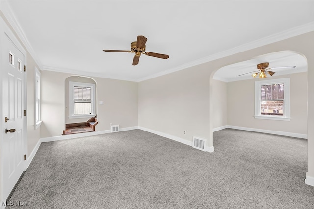 unfurnished room with crown molding, carpet flooring, and a wealth of natural light