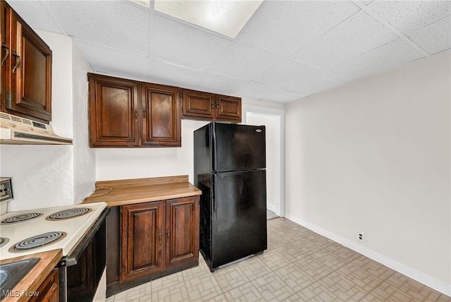 kitchen with black refrigerator, a paneled ceiling, and white electric stove