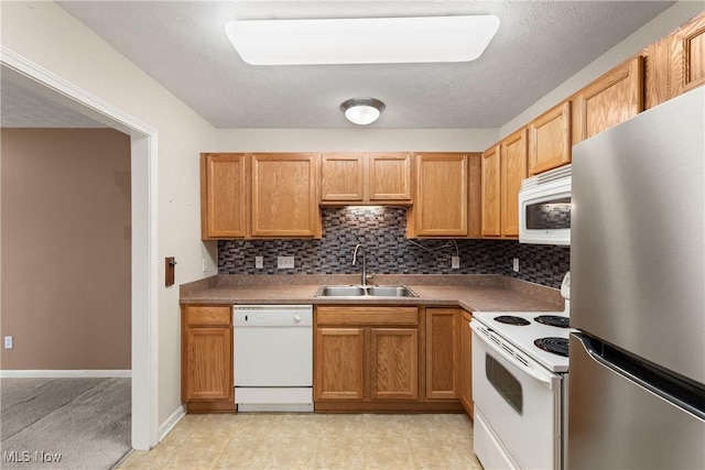 kitchen featuring sink, a textured ceiling, backsplash, and white appliances