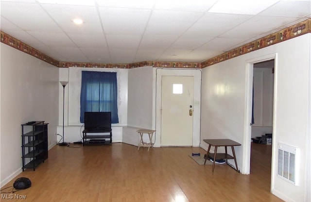 foyer entrance with hardwood / wood-style floors and a drop ceiling