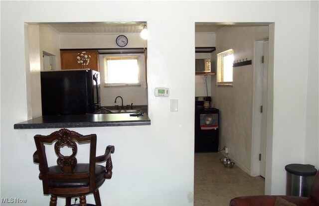 kitchen featuring range, sink, and black fridge