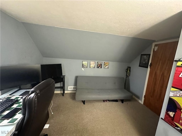 carpeted home office featuring vaulted ceiling and a textured ceiling