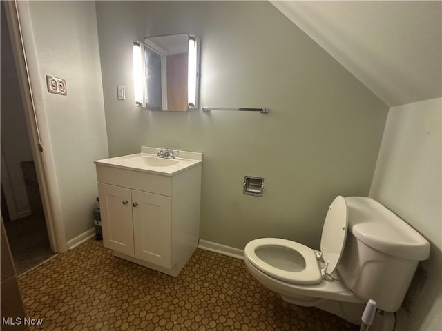 bathroom with vanity, toilet, and vaulted ceiling