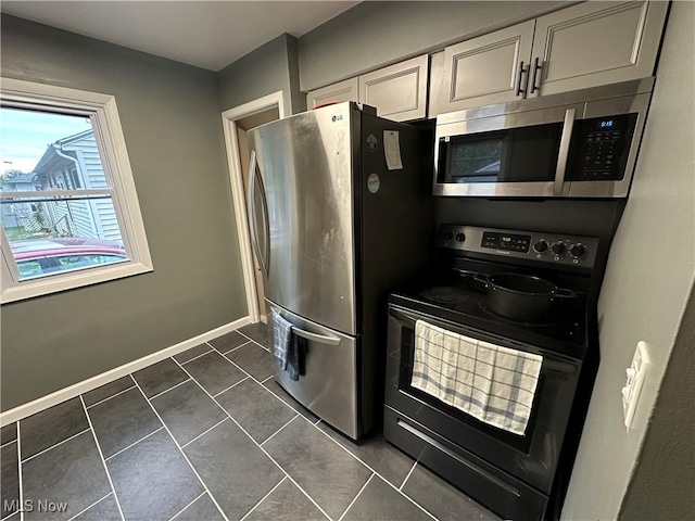 kitchen with appliances with stainless steel finishes and dark tile patterned flooring