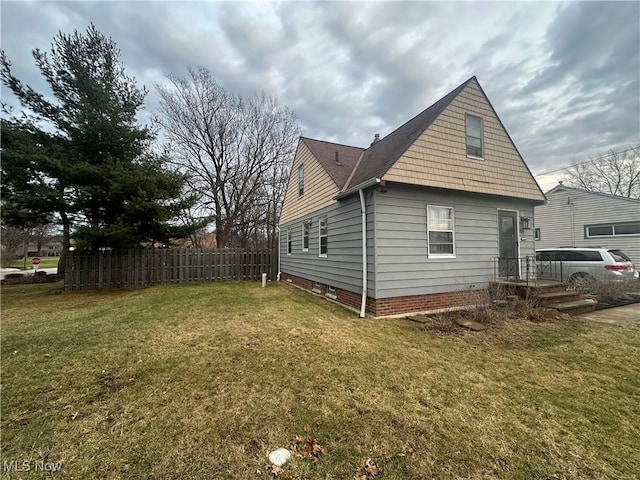 view of side of home with a yard