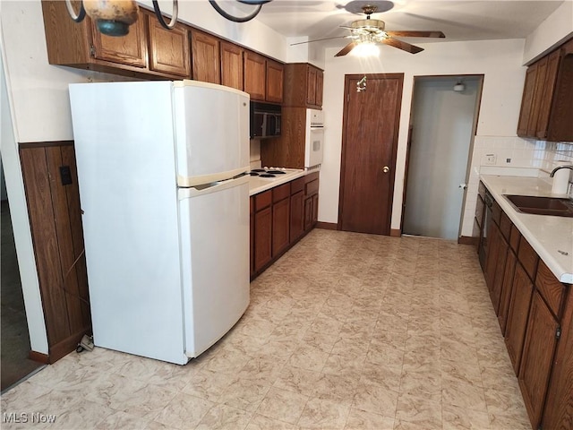 kitchen featuring ceiling fan, white appliances, sink, and decorative backsplash