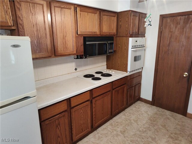 kitchen with tasteful backsplash and white appliances