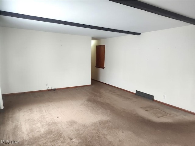 carpeted spare room featuring beam ceiling