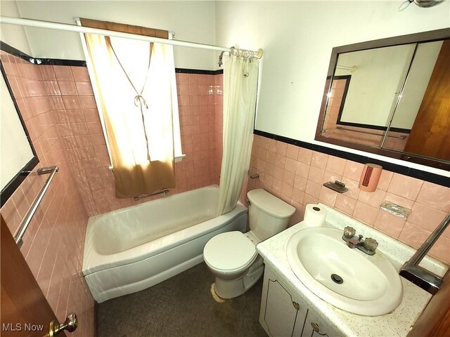 full bathroom featuring vanity, tile walls, shower / bath combination with curtain, and toilet