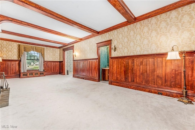 unfurnished living room featuring beamed ceiling and carpet floors