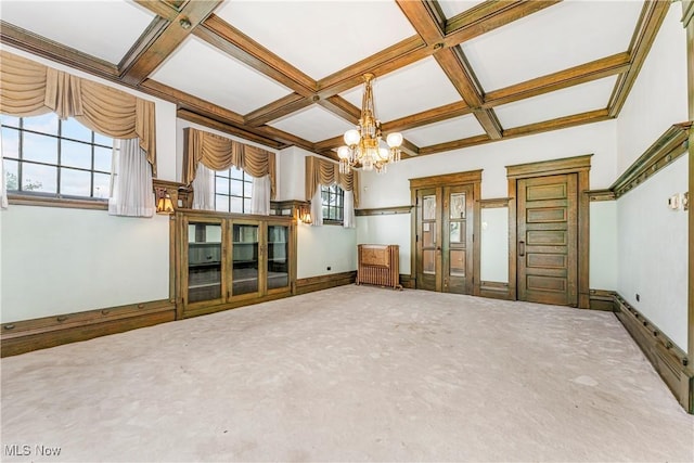 unfurnished living room featuring beamed ceiling, carpet, coffered ceiling, and a notable chandelier