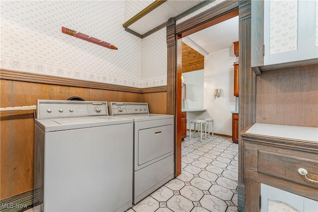 washroom with independent washer and dryer and wood walls