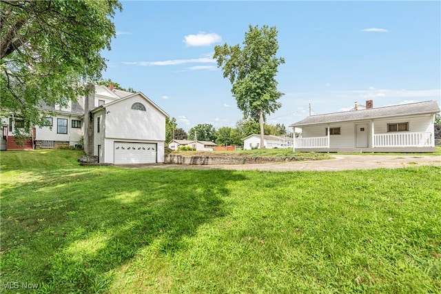 view of yard featuring a porch and a garage