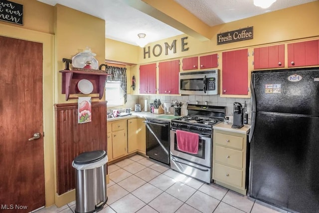 kitchen with light tile patterned flooring, decorative backsplash, beam ceiling, and black appliances