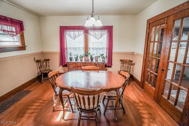 dining area with wood-type flooring and a chandelier