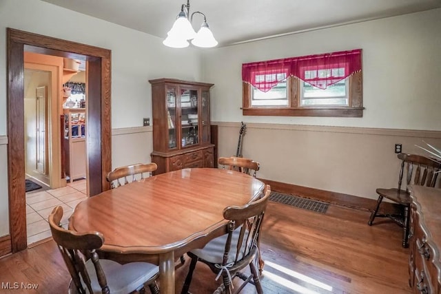 dining area with an inviting chandelier and light hardwood / wood-style floors