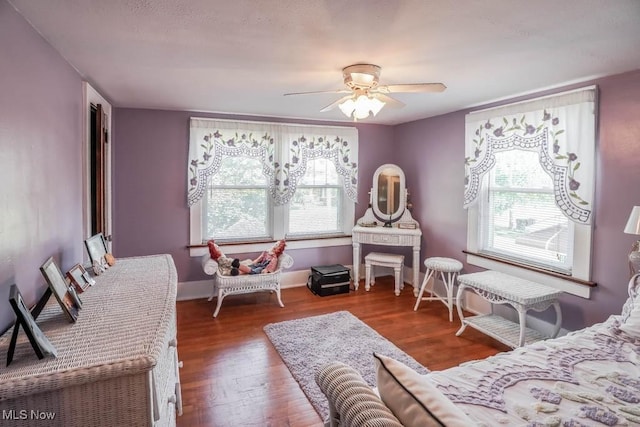 living area with ceiling fan and dark hardwood / wood-style flooring