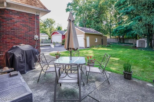 view of patio / terrace with grilling area, a storage unit, and a garage