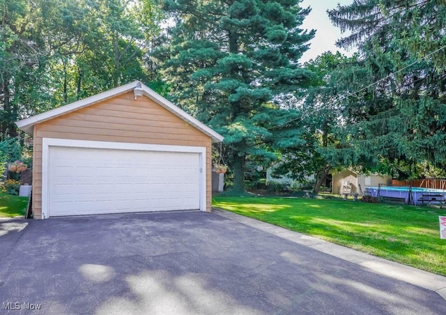 garage featuring a pool and a yard