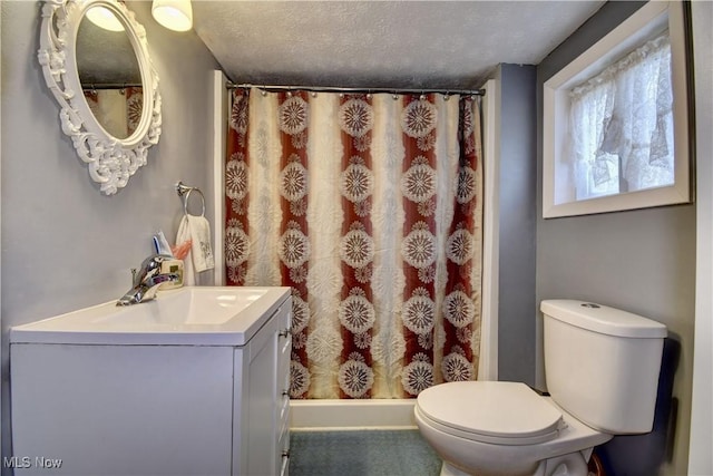 bathroom featuring a shower with curtain, vanity, toilet, and a textured ceiling